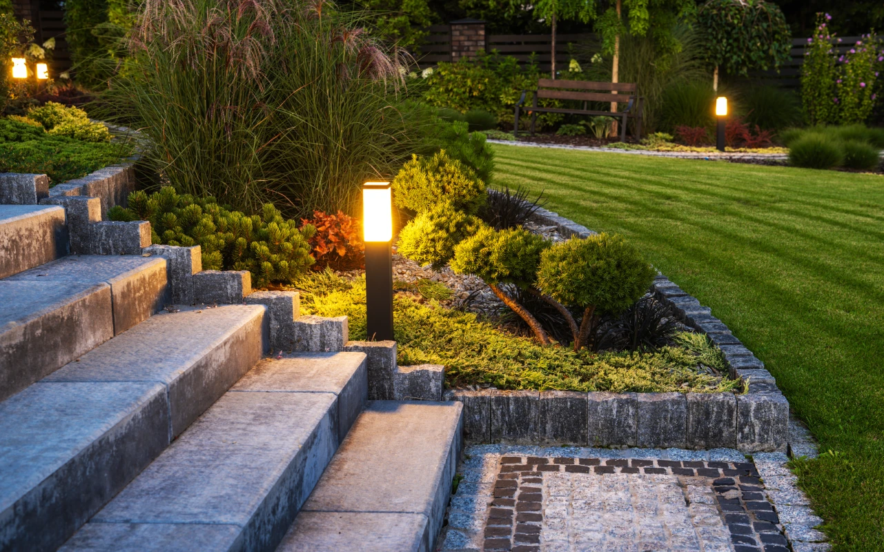 Granite block steps with low path light and ornamental grasses at twilight, Massachusetts front yard