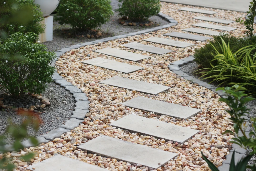 Modern stepping stone path through decorative gravel with shrub landscape, Massachusetts yard