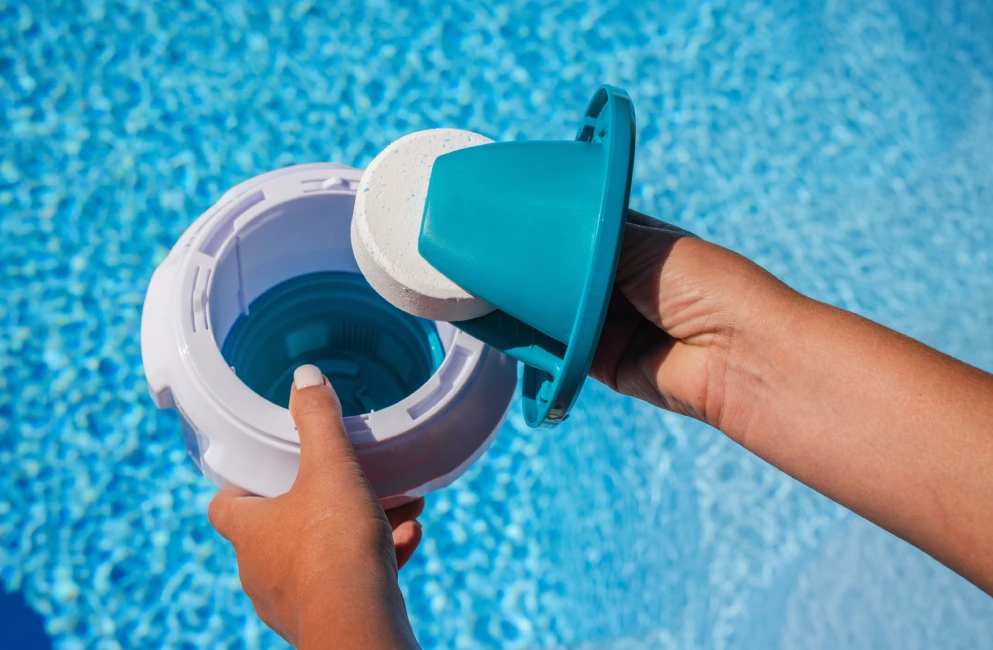 Adding chlorine tablet to floating dispenser for Massachusetts pool care