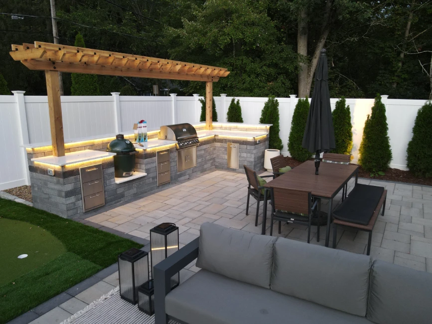 Outdoor kitchen with pergola and dining area