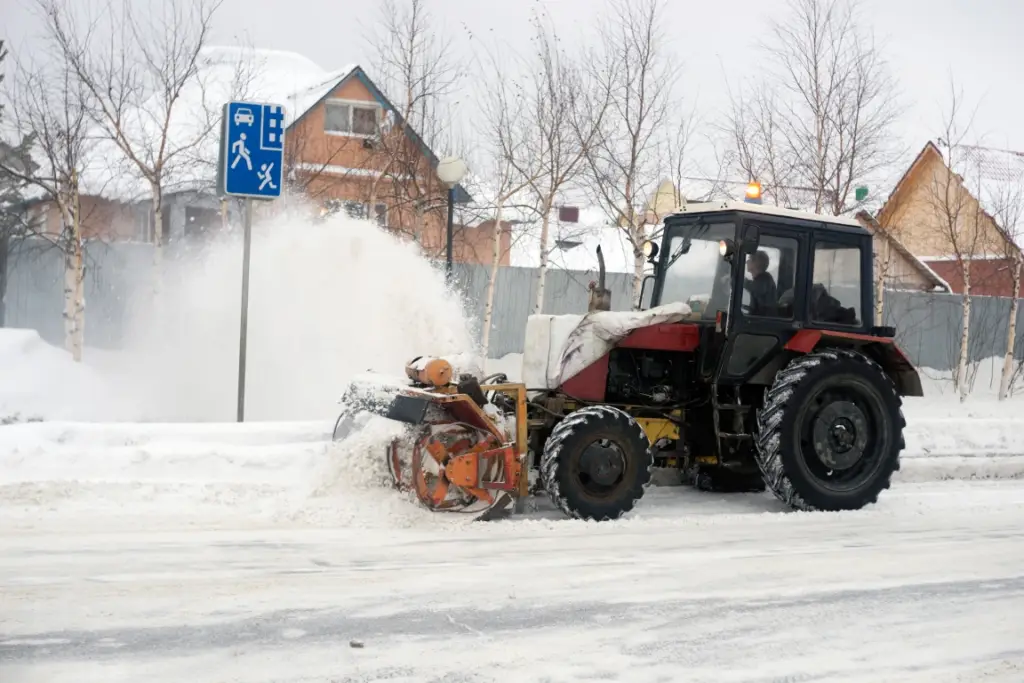 Tractor with snow blower attachment clearing Massachusetts city street