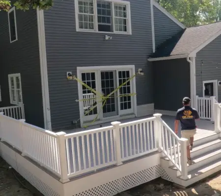 Backyard deck installation with white railings and stairs Newton MA