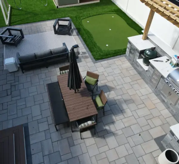 Multi-zone paver patio outdoor kitchen dining seating areas Winchester MA aerial hardscape design