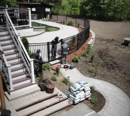 Crew installing black aluminum pool fence