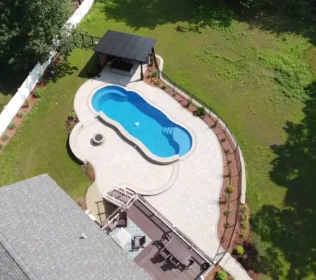 Curved pool with patio and pavilion aerial