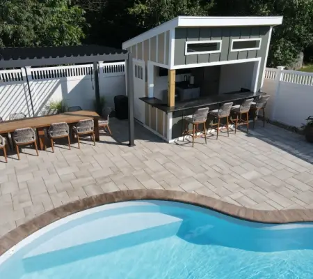 Custom outdoor kitchen and poolside paver patio design in Massachusetts