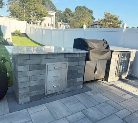 Custom stone outdoor kitchen with built-in grill Gloucester Massachusetts