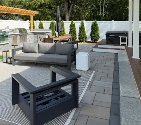 Modern paver patio outdoor kitchen lounge seating white fence Winchester MA contemporary hardscape design