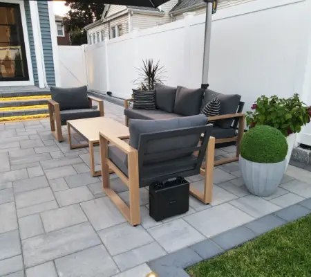 Modern paver patio with outdoor lounge seating and privacy fence Lexington MA