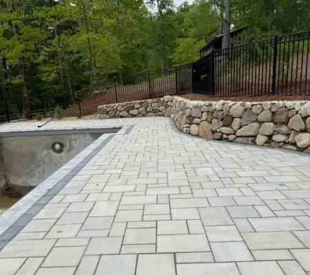 Pool deck paver installation with stone retaining wall Lynnfield MA