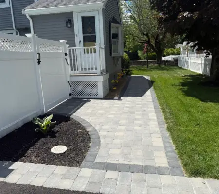 Sod lawn installation Massachusetts side yard paver walkway white fence mulch beds