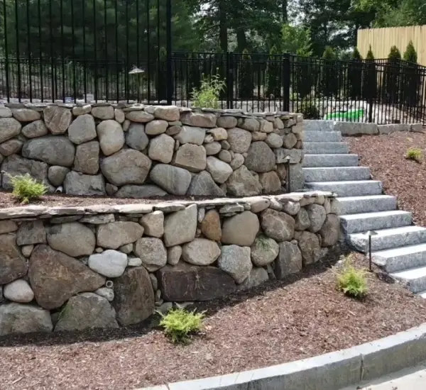 Multi-tier natural stone retaining wall with granite steps Winchester MA terraced landscaping pool area