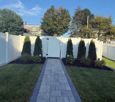 White privacy fence with arborvitae screening
