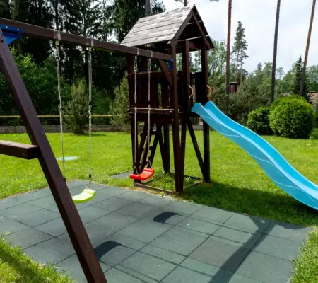 Wooden A-frame swing set with blue wavy slide and rubber-tile safety surface, Wakefield MA